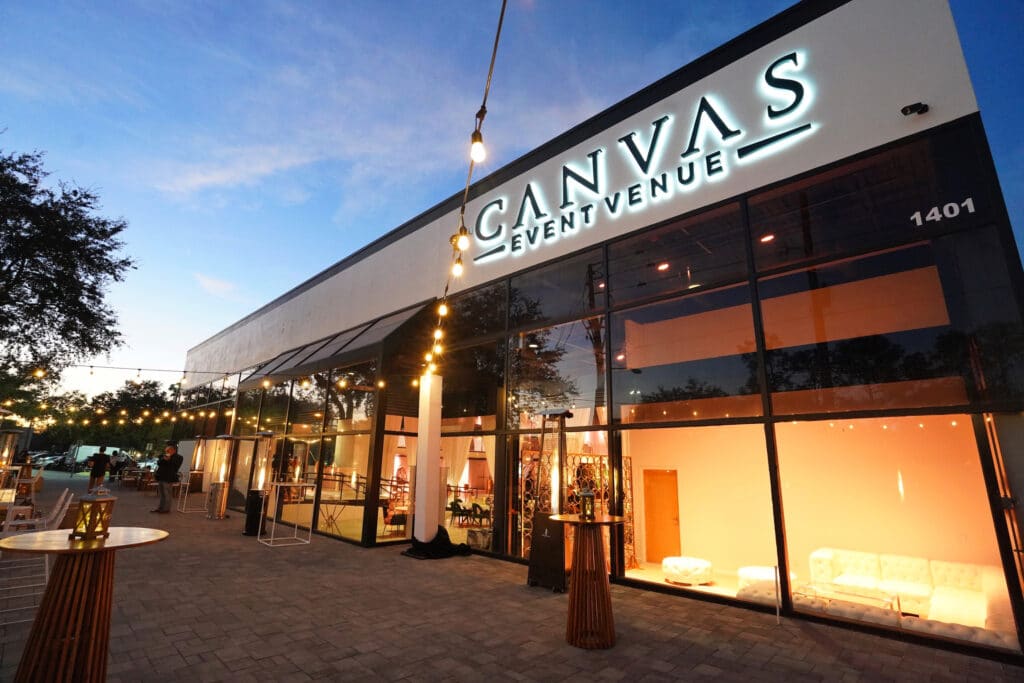 canvas event venue, a modern white building with large windows lit up at night